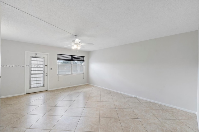 tiled empty room with ceiling fan and a textured ceiling