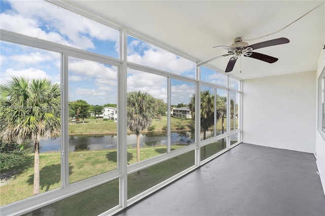 unfurnished sunroom featuring a water view and ceiling fan