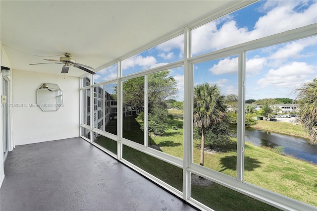 unfurnished sunroom with a water view, ceiling fan, and a healthy amount of sunlight