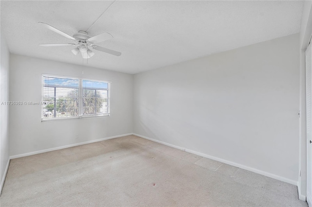 unfurnished room featuring light carpet, ceiling fan, and a textured ceiling