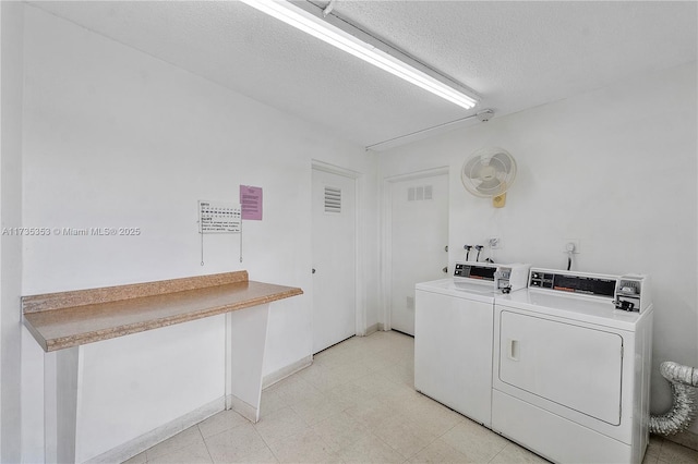 washroom with washing machine and dryer and a textured ceiling