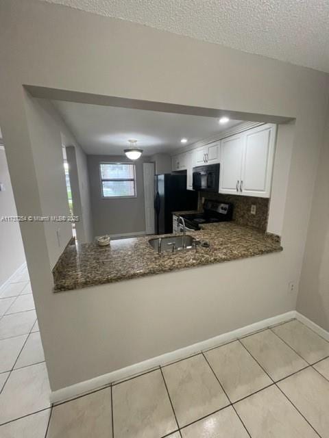 20810 NE 8th Ct Unit 104-18, Miami, FL 33179 - kitchen with sink, black appliances, kitchen peninsula, white cabinets, and dark stone counters