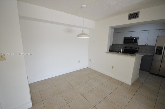 kitchen featuring a peninsula, visible vents, appliances with stainless steel finishes, tasteful backsplash, and pendant lighting