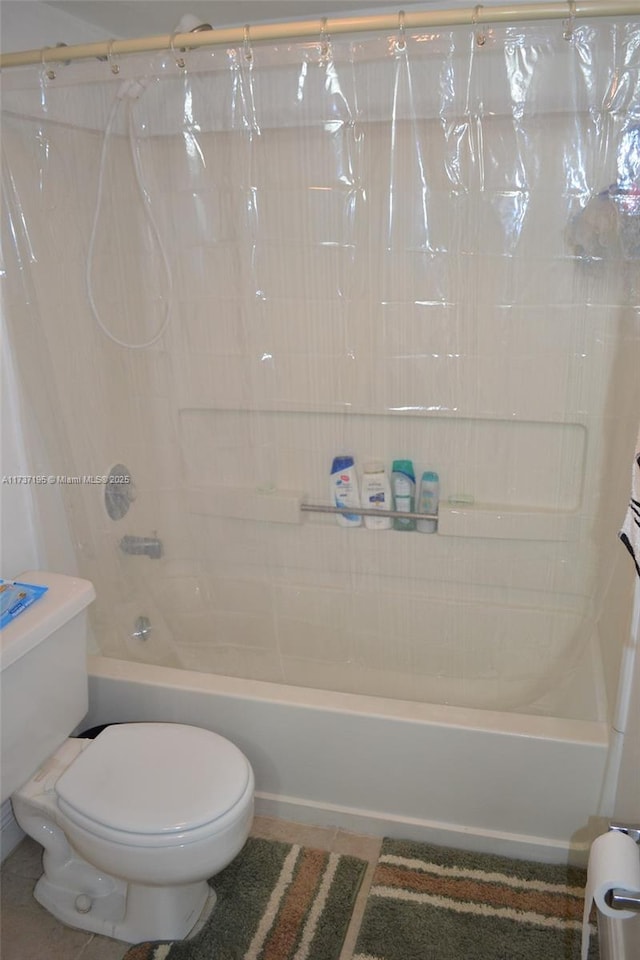 full bath featuring shower / bath combo, tile patterned flooring, and toilet