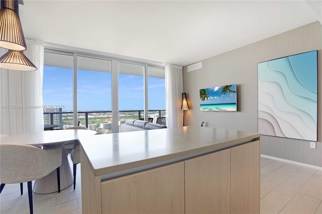 kitchen featuring floor to ceiling windows, a center island, and light brown cabinets