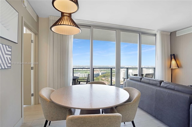 tiled dining room featuring floor to ceiling windows