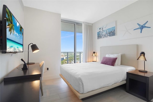 bedroom featuring expansive windows and access to exterior