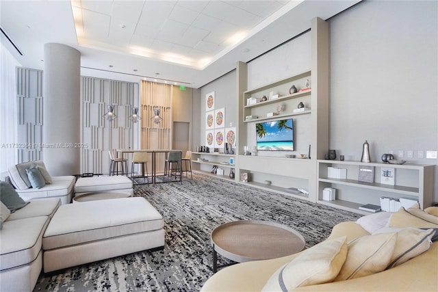 living room featuring a tray ceiling and built in features