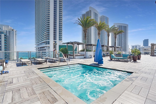 view of swimming pool featuring a hot tub, a patio, and a pergola