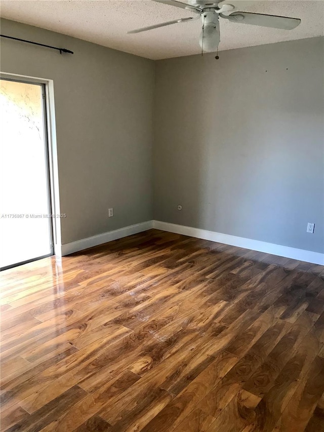 unfurnished room featuring ceiling fan, wood-type flooring, and a textured ceiling