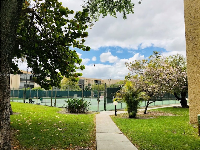 view of home's community featuring a yard and tennis court