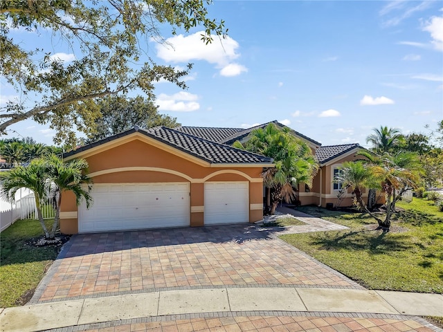 mediterranean / spanish-style home with a garage and a front lawn