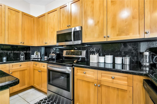 kitchen with tasteful backsplash, light tile patterned flooring, and appliances with stainless steel finishes