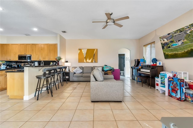 tiled living room with ceiling fan