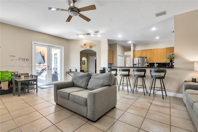 living room featuring light tile patterned floors, ceiling fan, and french doors