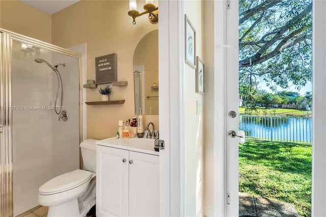 bathroom with vanity, a shower with shower door, toilet, and a water view