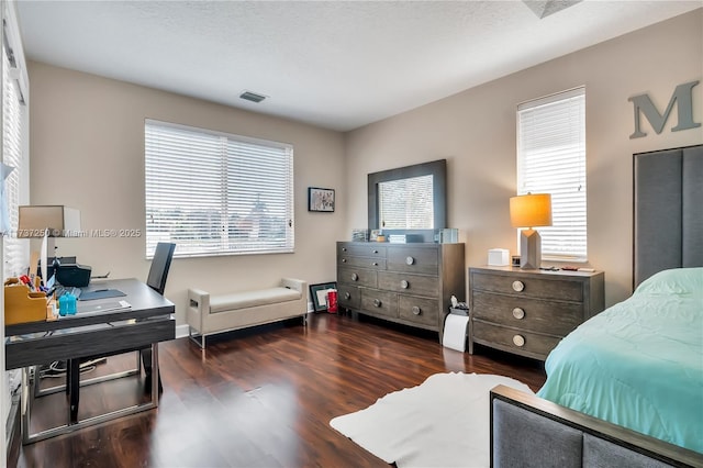 bedroom with dark wood-type flooring, multiple windows, and a textured ceiling