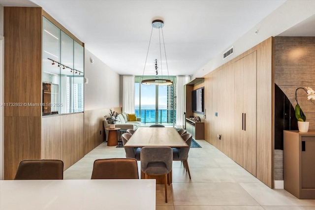 dining area featuring light tile patterned floors and wood walls