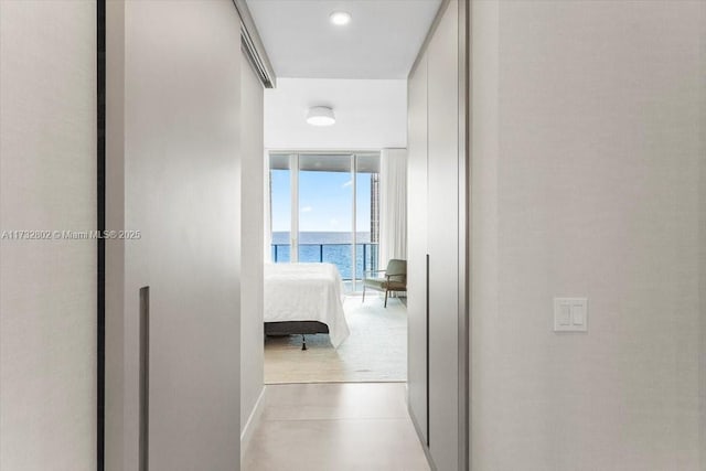 corridor with floor to ceiling windows and a water view