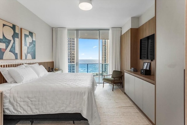 bedroom featuring a wall of windows, light colored carpet, and access to outside