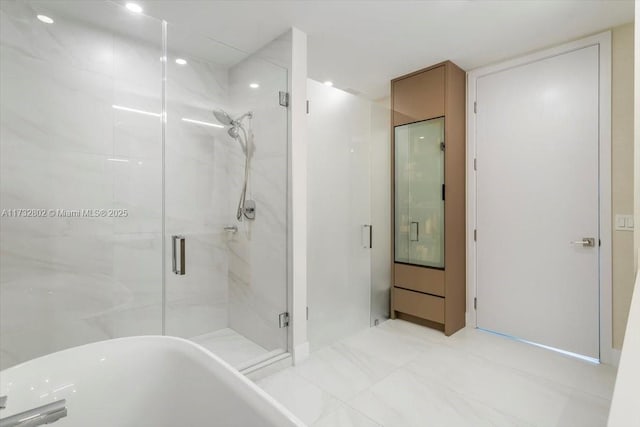 bathroom featuring shower with separate bathtub