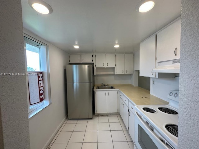 kitchen featuring white cabinetry, light tile patterned floors, electric range, and stainless steel refrigerator