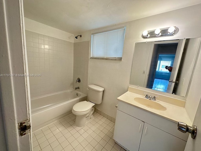 full bathroom with tiled shower / bath combo, vanity, tile patterned floors, and toilet