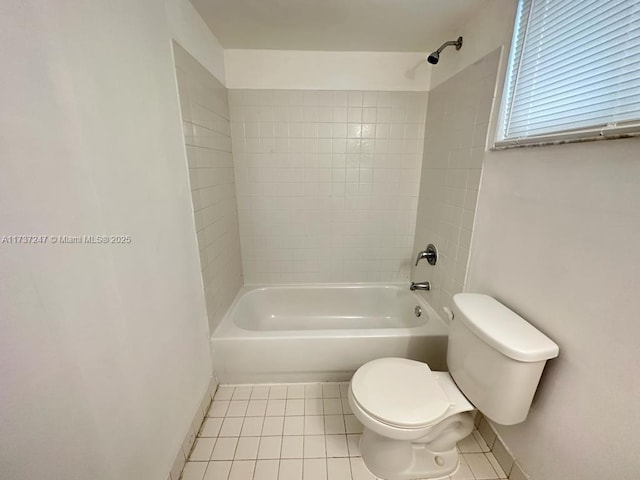 bathroom with tiled shower / bath, toilet, and tile patterned flooring