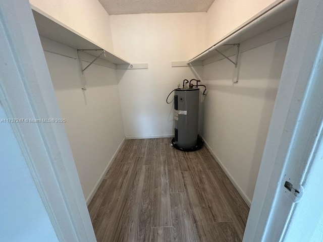 spacious closet featuring hardwood / wood-style flooring and water heater