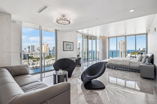 bedroom featuring a water view, a wall of windows, multiple windows, and access to outside