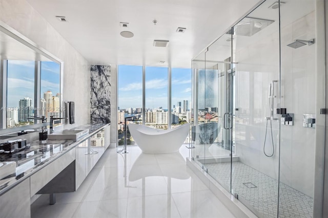 bathroom with expansive windows, tile patterned floors, vanity, and separate shower and tub