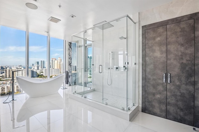 bathroom with tile patterned flooring, shower with separate bathtub, and a wall of windows