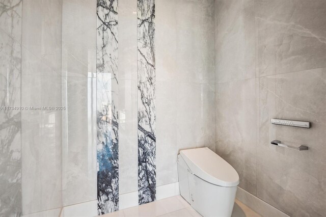 bathroom with tile walls and toilet