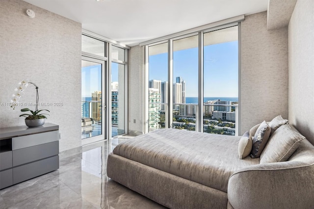 bedroom featuring expansive windows and access to outside