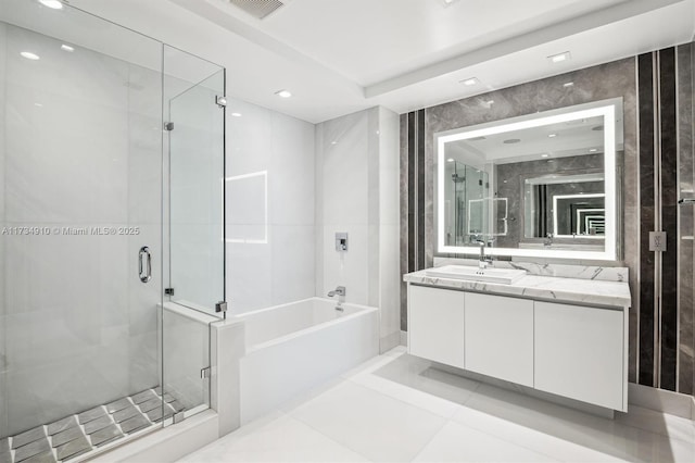 bathroom featuring tile patterned floors, vanity, and shower with separate bathtub