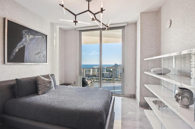 bedroom featuring expansive windows, access to outside, and a chandelier