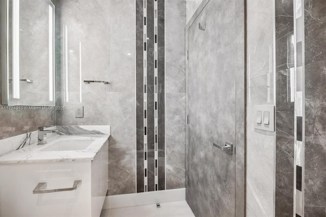 bathroom with vanity and tile walls