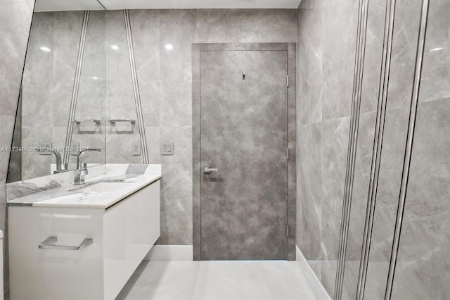 bathroom featuring vanity and tile walls