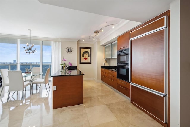 kitchen featuring double oven, hanging light fixtures, ornamental molding, and a kitchen island