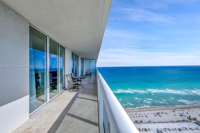 balcony featuring a water view and a beach view