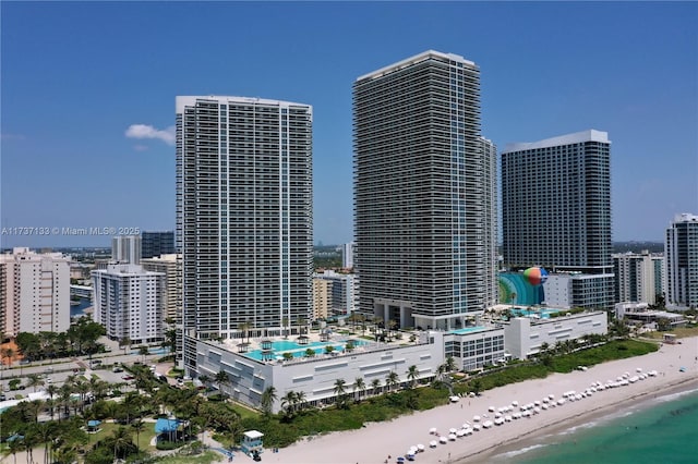 property's view of city featuring a water view and a beach view