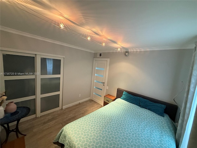 bedroom with hardwood / wood-style floors and crown molding