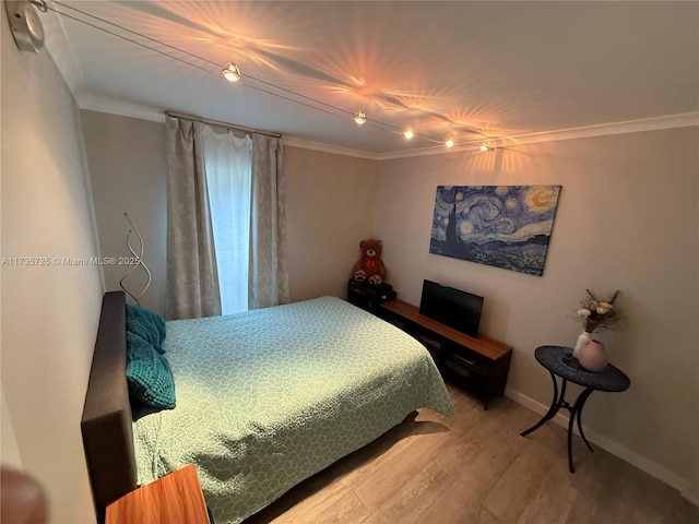 bedroom with ornamental molding and hardwood / wood-style floors