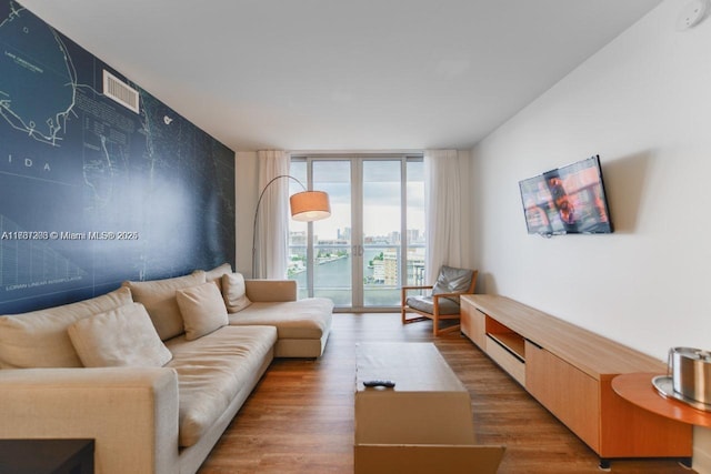 living room with floor to ceiling windows, wood-type flooring, and french doors