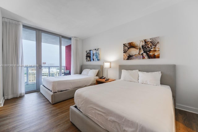 bedroom with access to exterior, dark hardwood / wood-style floors, and expansive windows