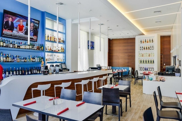 bar featuring built in shelves and light hardwood / wood-style floors