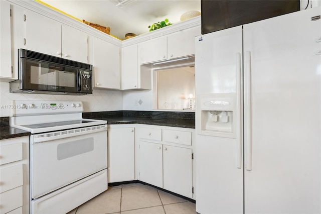 kitchen featuring light tile patterned floors, white appliances, white cabinetry, dark stone countertops, and decorative backsplash