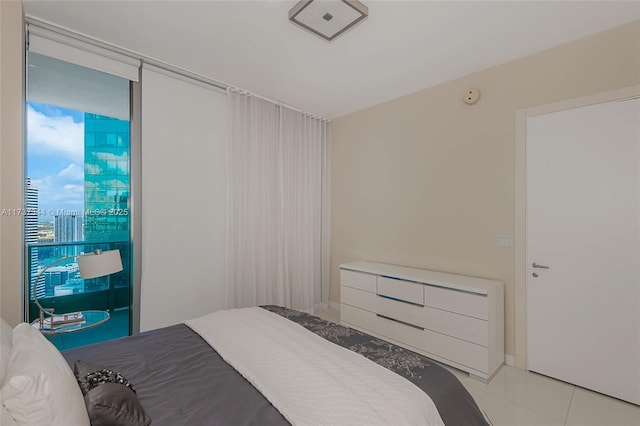 bedroom featuring floor to ceiling windows and light tile patterned floors