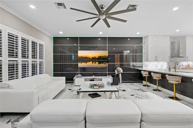 living room featuring sink, crown molding, and ceiling fan