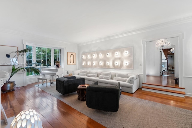 living area featuring a notable chandelier, ornamental molding, and hardwood / wood-style floors